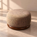 Hekolina Brown Round Ottoman product photo showing rounded upholstered body and woven-look texture in a clean studio setting.