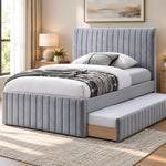 Bexylona Grey Kids Trundle Bed, detailed with a padded panel headboard and a matching footboard in a furnished bedroom.