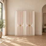 Lottomira 4 Door Wooden Wardrobe combines circular brass-tone handles with flowing grooved patterns in a sunlit bedroom.