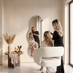 Close-up of Nutmegy Wavy Salon Mirror, highlighting wavy organic shape and full-length reflection in a modern home setting.