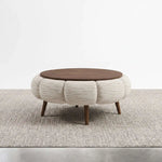 Octopump Round Upholstered Wooden Coffee Table featuring round design in a clear product photograph in a modern home setting.