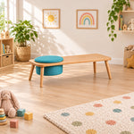 Stepsoly Kids Wooden Floor Table with Pouf beside a playroom window, featuring a round teal pouf and a light wood finish.