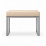 Cream beige leather upholstery tops the Bencivola Pedicure Footrest, above stitched cushion edges and a slim metal frame.