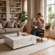 Lumi Solid Surface Gold White Coffee Table with a sleek marble-like finish in a modern living room setting featuring neutral tones and natural light.