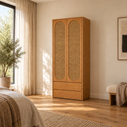 Alvarario 2 Door Wooden Cane Wardrobe with Drawer, detailed with two tall cane-panel doors beside a bedroom window.