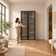 Balomora 2 Door Transparent Glass Cabinet Storage with visible storage shelves, beside a woman reaching toward the door.