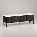 Chestiko White Marble Top TV Unit in a softly lit studio, showing fluted black drawers alongside straight cabinet edges.