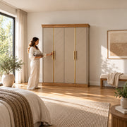 Dolbarino 4 Door Wooden Wardrobe, chevron-patterned doors and a wood-tone base, with a woman standing beside the cabinet.