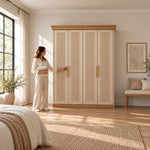 Dolbarino 4 Fluted Door Wooden Wardrobe with four vertically fluted doors, beside a woman reaching toward the door.