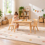Dukyshola Wooden Kids Table with 2 Chairs: spindle-back chairs beside a child seated at the table on a patterned rug.