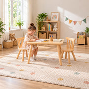Dukyshola Wooden Kids Table with 2 Chairs: spindle-back chairs beside a child seated at the table on a patterned rug.