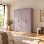 Elegitora Lavender 4 Door Fluted Wardrobe pairs paired brass-tone pulls with a straight plinth base in a sunlit bedroom.