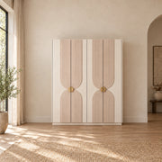 Lottomira 4 Door Wooden Wardrobe combines circular brass-tone handles with flowing grooved patterns in a sunlit bedroom.