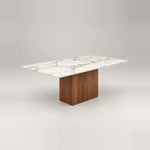 Ludwista Marble Top 6-Seater Dining Table combines warm wood grain with a broad central pedestal against a grey backdrop.