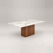 Ludwista Marble Top 6-Seater Dining Table combines warm wood grain with a broad central pedestal against a grey backdrop.