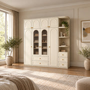 Rakilony 4 Door Wardrobe with Side Shelves, detailed with rounded side shelving and upper cupboards in a sunlit bedroom.