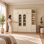 Rakilony 4 Door Wardrobe with Side Shelves with a woman standing beside the cabinet, showing central glass-front shelves.