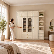Rakilony 4 Door Wardrobe with Side Shelves with a woman standing beside the cabinet, showing central glass-front shelves.