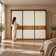 Sidedora 3 Sliding Door Wardrobe beside a woman reaching toward the door; a wood-look outer frame and dark panel edging.