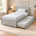 Stompora Grey Kids Trundle Bed displays a curved grey headboard together with a framed footboard against a bedroom wall.