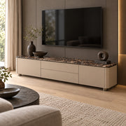 Vicindola Marble Top TV Unit beside living room seating, showing short recessed feet alongside taupe cupboard fronts.