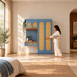 Webinora Blue Wooden Cane Wardrobe with Dressing Table beside a woman reaching toward the door, featuring an upper cupboard.