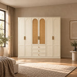 Wratinora 6 Door Wooden Wardrobe with Drawers in a furnished bedroom, featuring brass-tone pulls and cream arched doors.